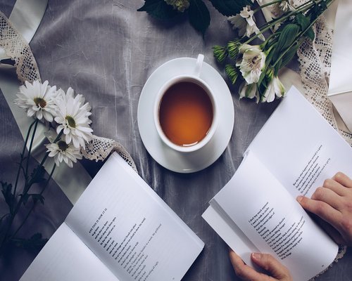 A cup of herbal tea next to a book
